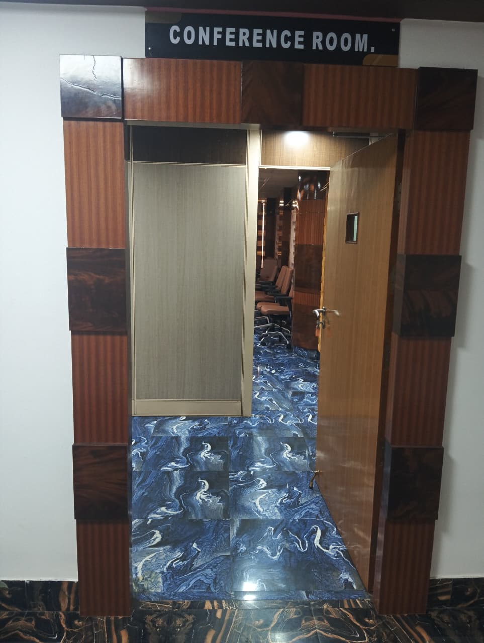 The signed entrance to the conference room, door open onto the seating.