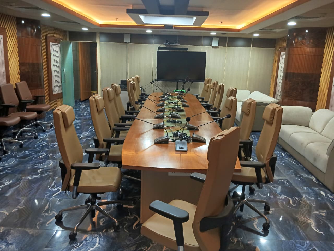 The conference room seen from the head of the table, facing the display wall.
